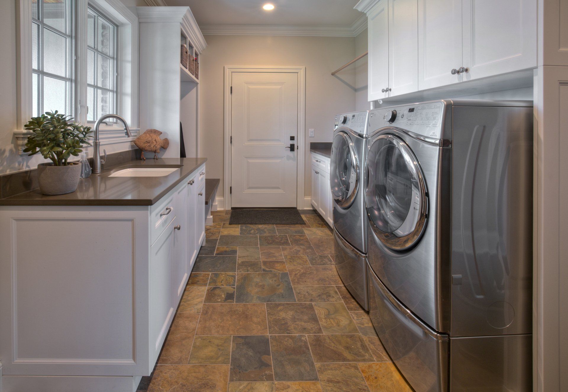 A laundry room with a washer and dryer and a sink.