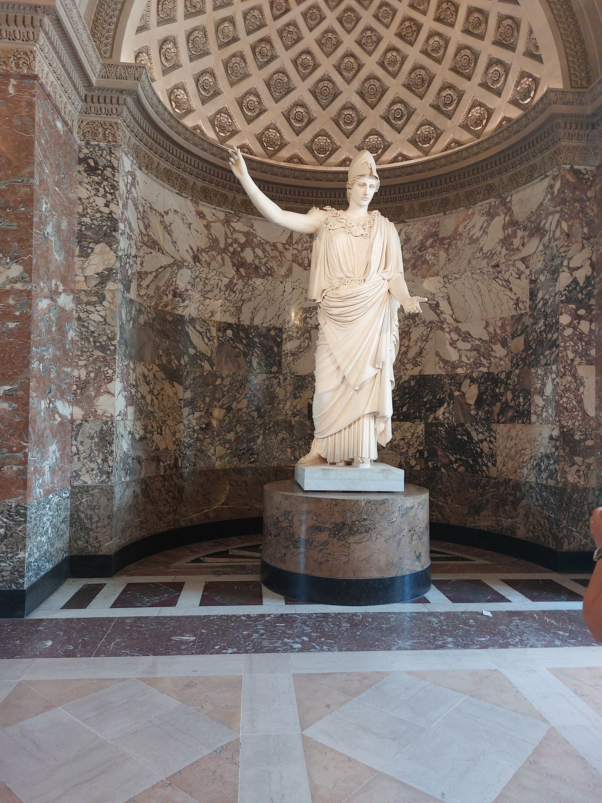 Una statua di una donna in piedi davanti a una cupola