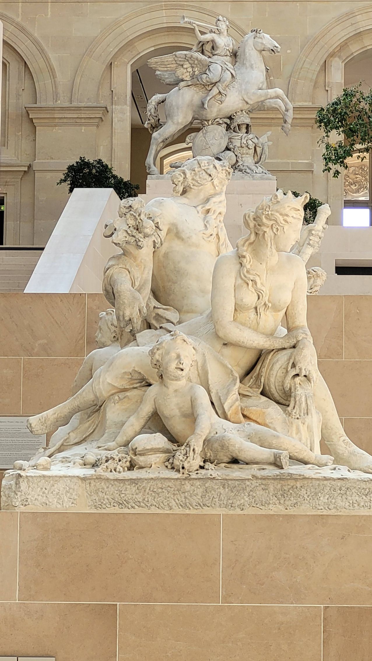 Una statua di un uomo e una donna circondati da bambini e da un cavallo.