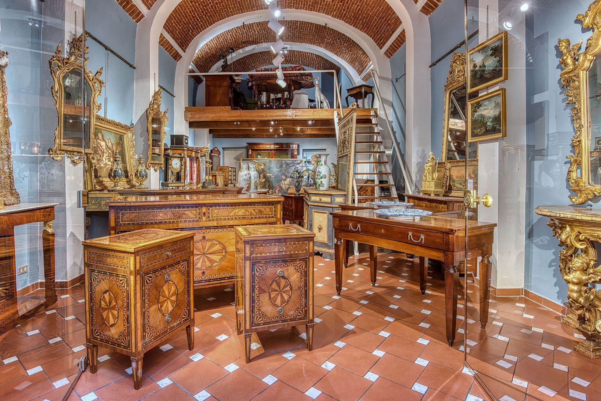 Una stanza piena di mobili e dipinti antichi.