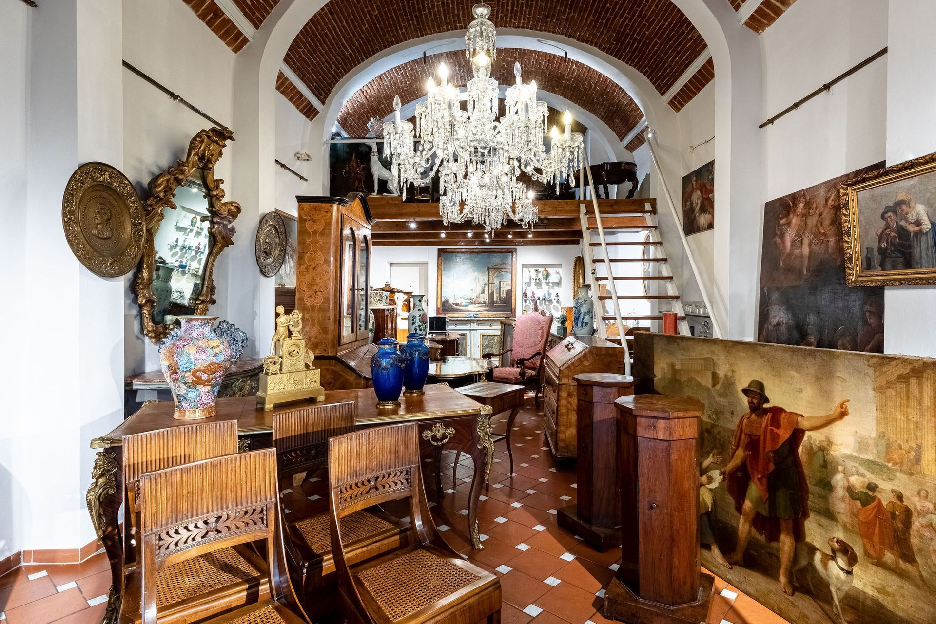 Una stanza con un tavolo, sedie e un lampadario