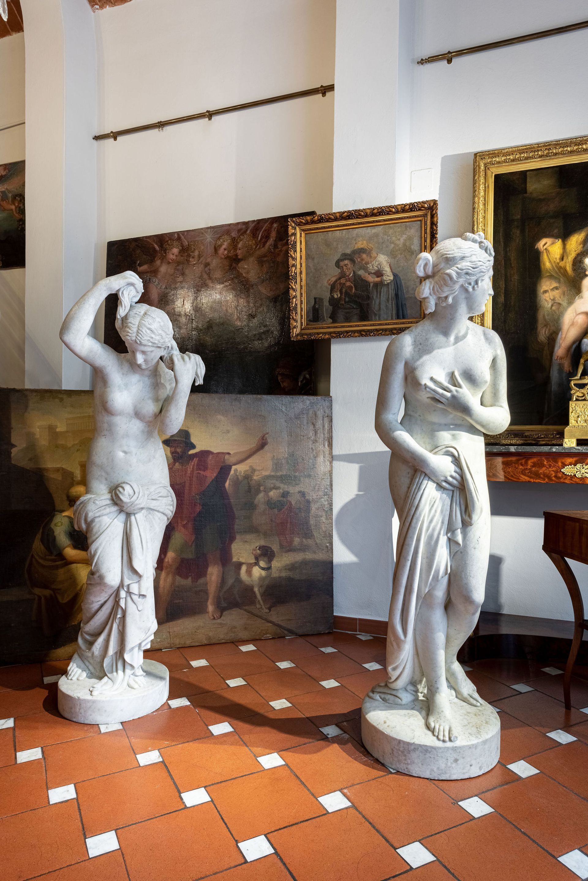 Due statue di donne sono in piedi una accanto all'altra in una stanza.