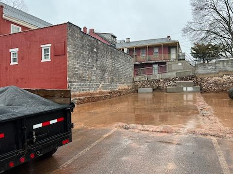 A dump truck is parked in front of a flooded building.
