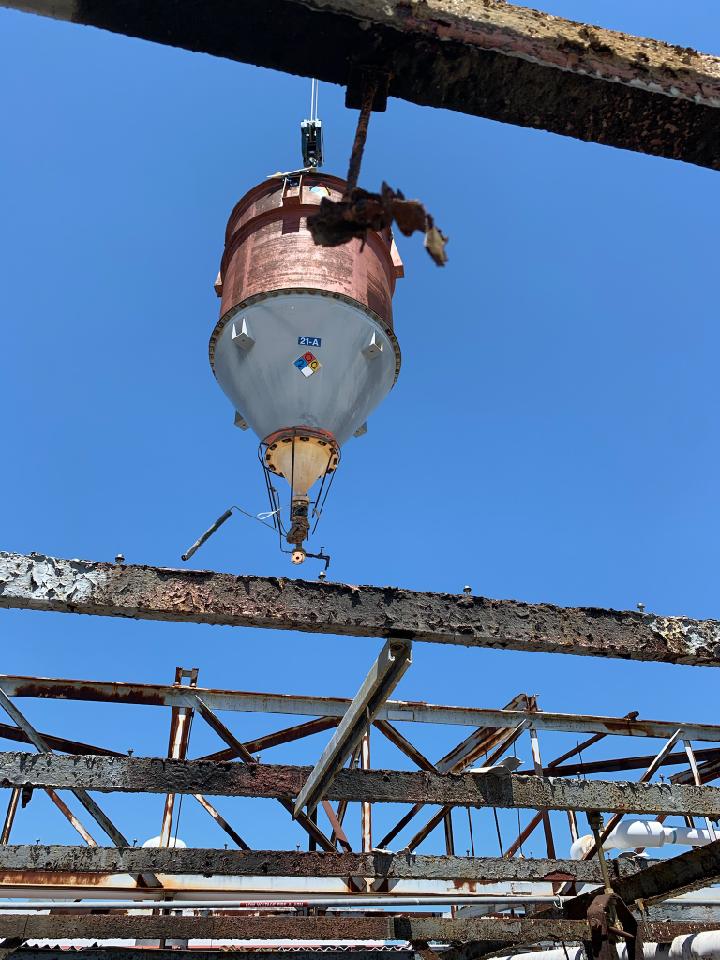 A light hanging from a metal structure with a blue sky in the background