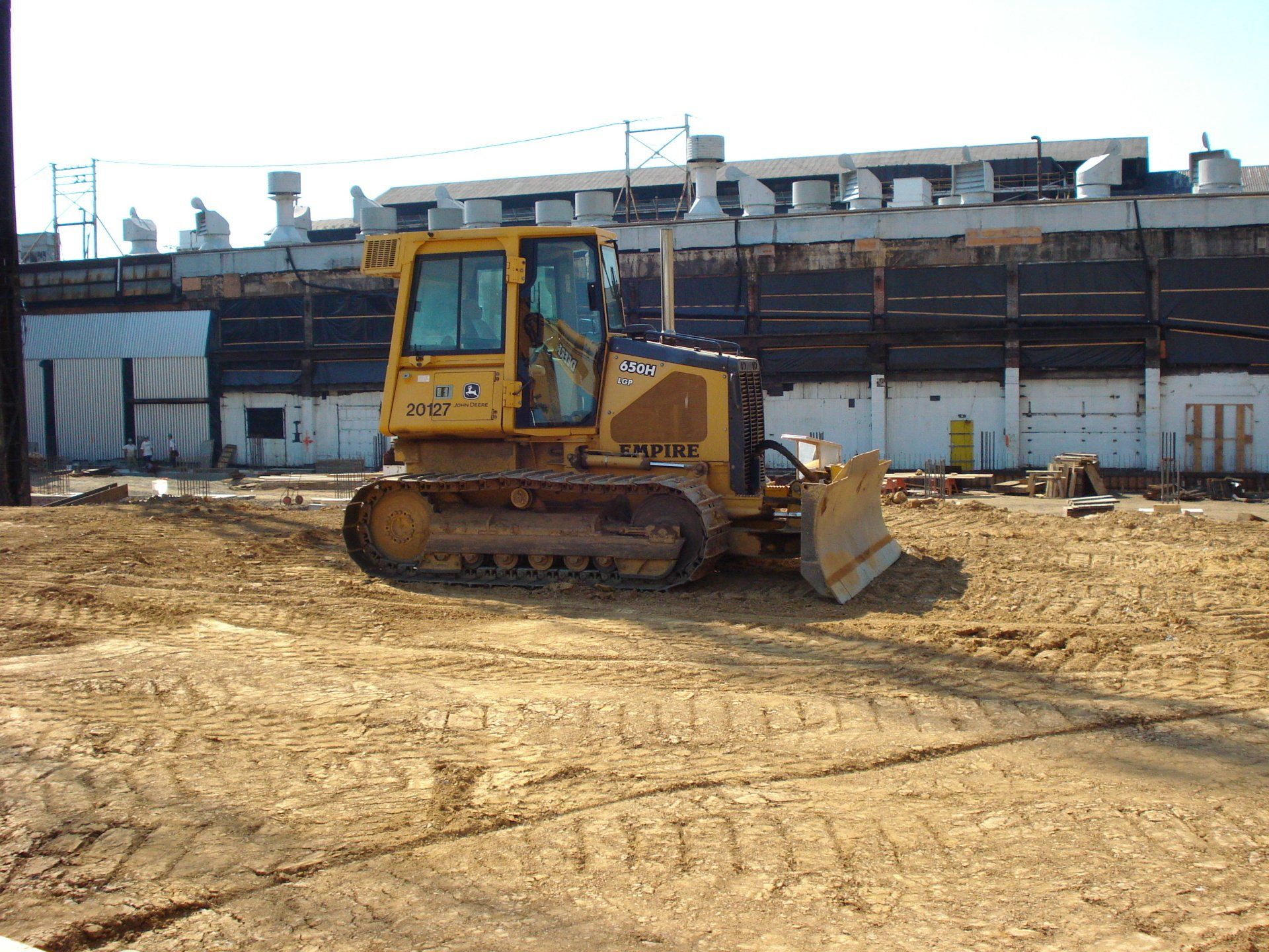 A yellow bulldozer is parked in a dirt field