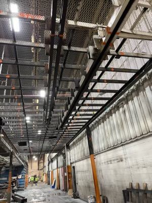 A large warehouse with a ladder hanging from the ceiling.