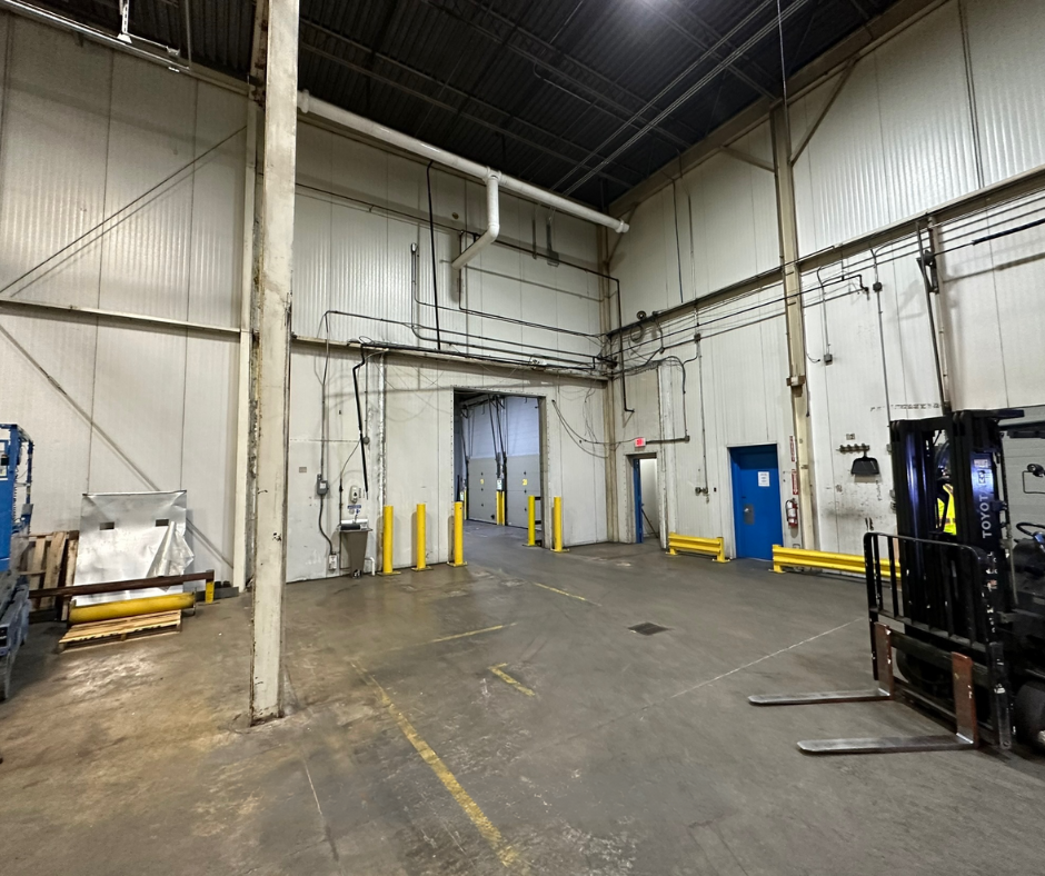 An empty warehouse with a forklift in the middle