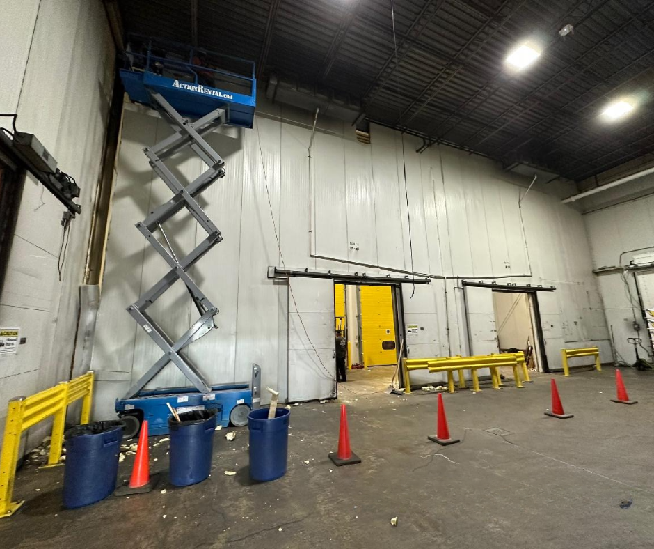 A warehouse with a scissor lift in the middle of it