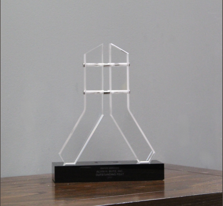 Outstanding Feat award for 2022 - a clear acrylic sculpture on a black base that says a. j. blitz inc.