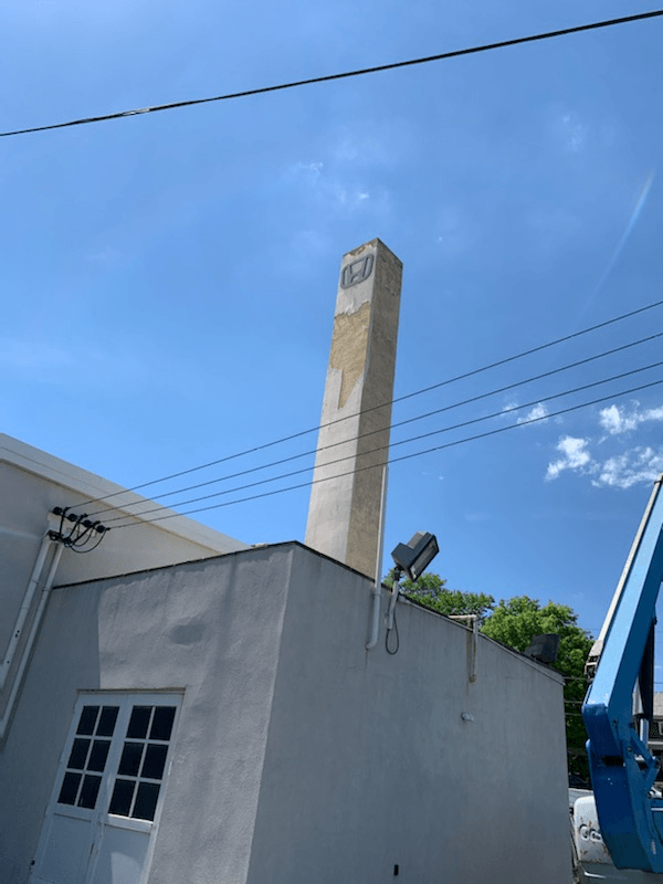 A large chimney is sitting on the side of a building.