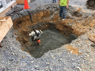 A man is standing in a hole in the ground.