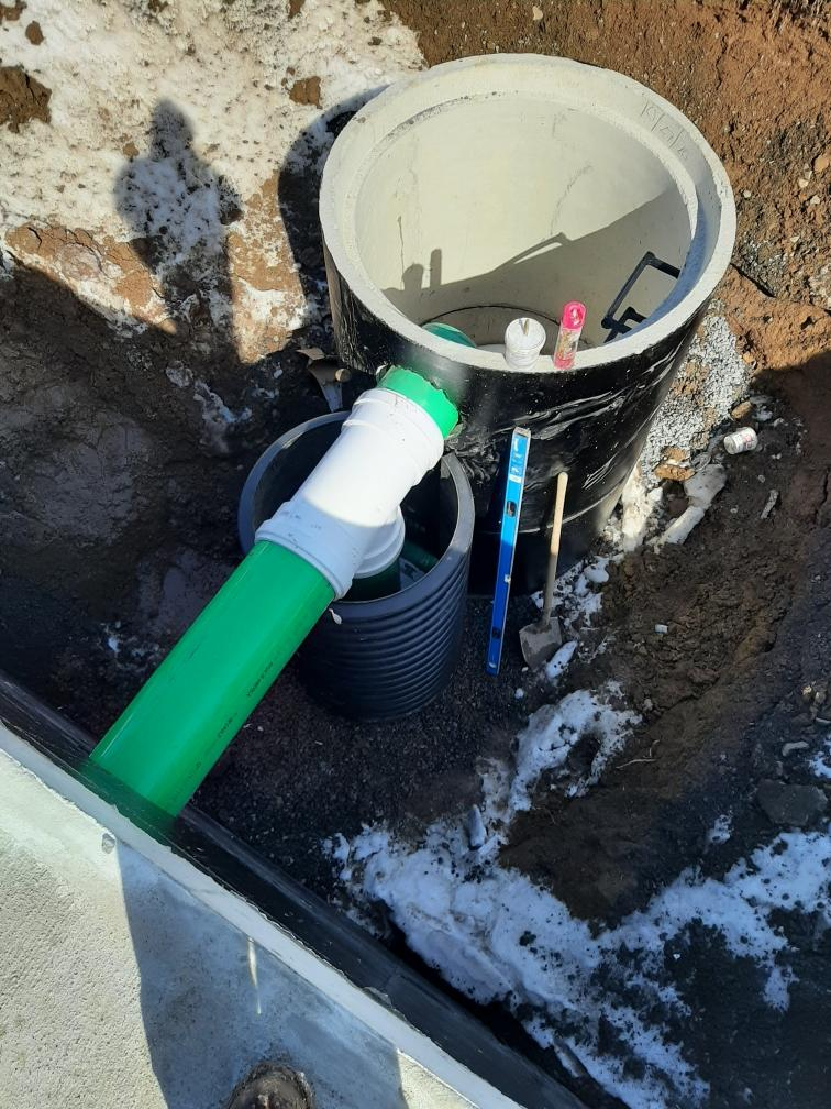 A green pipe is attached to a black bucket