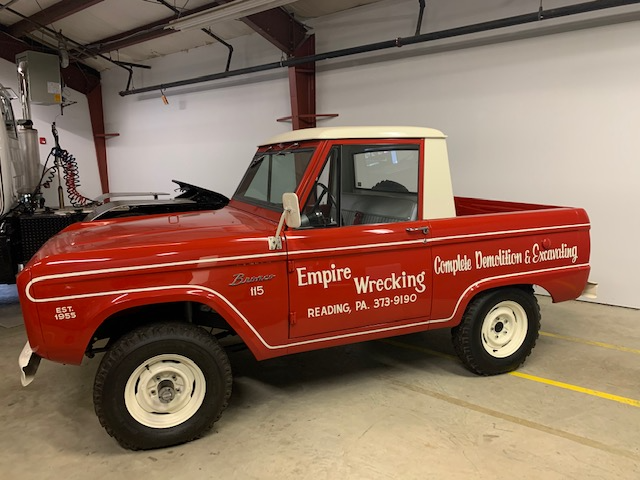 A red empire wrecking truck is parked in a garage