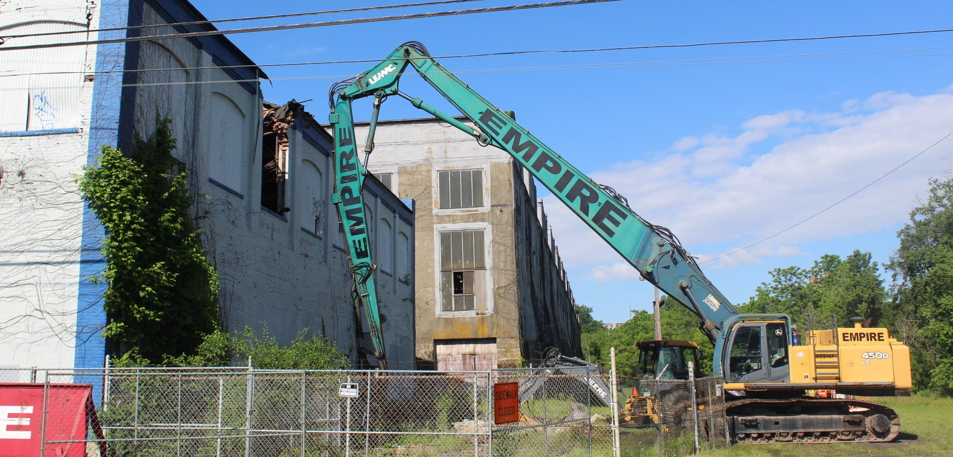 A large crane with the word empire on it is being used to demolish a building.