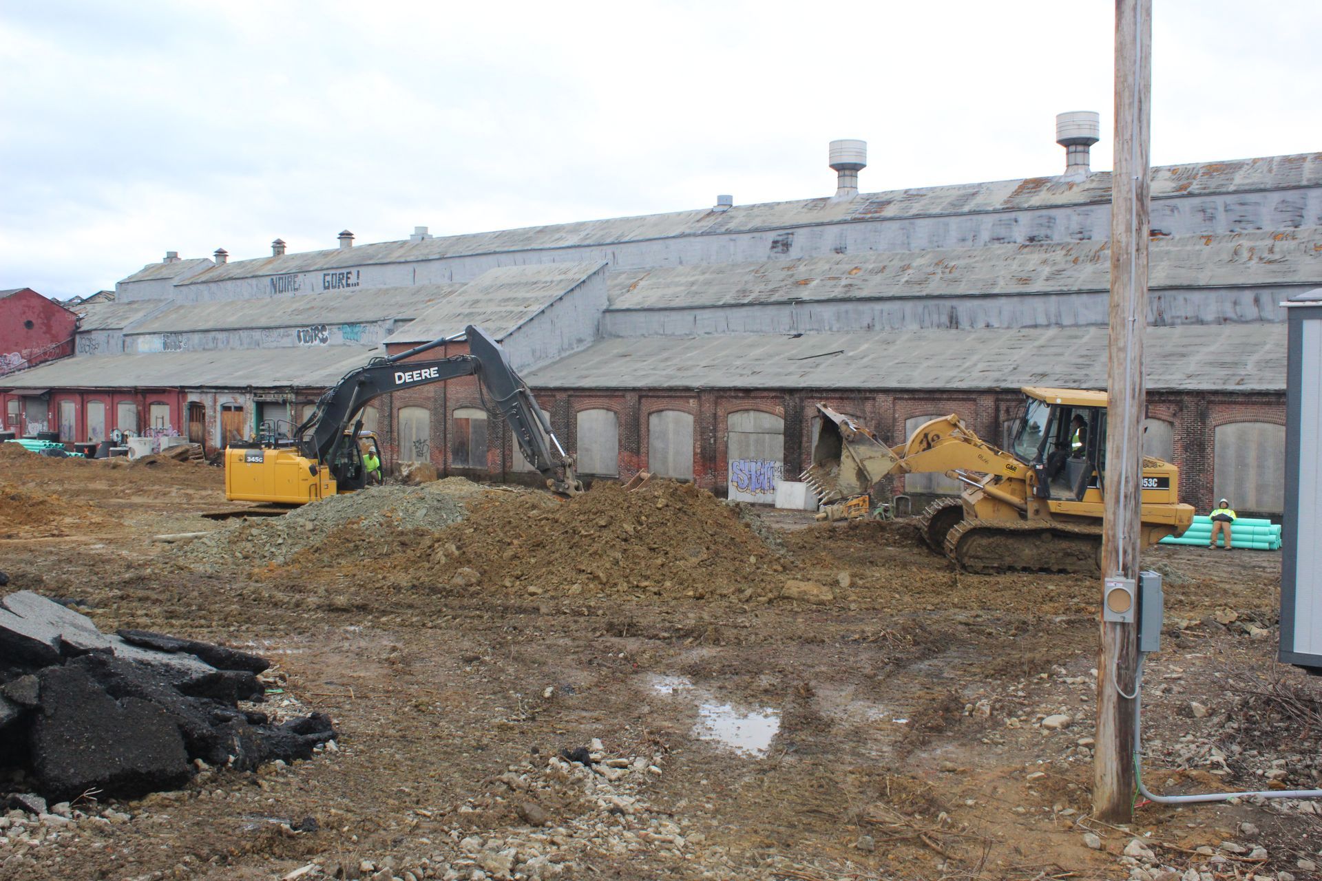 A construction site with a building in the background and a bulldozer in the foreground.