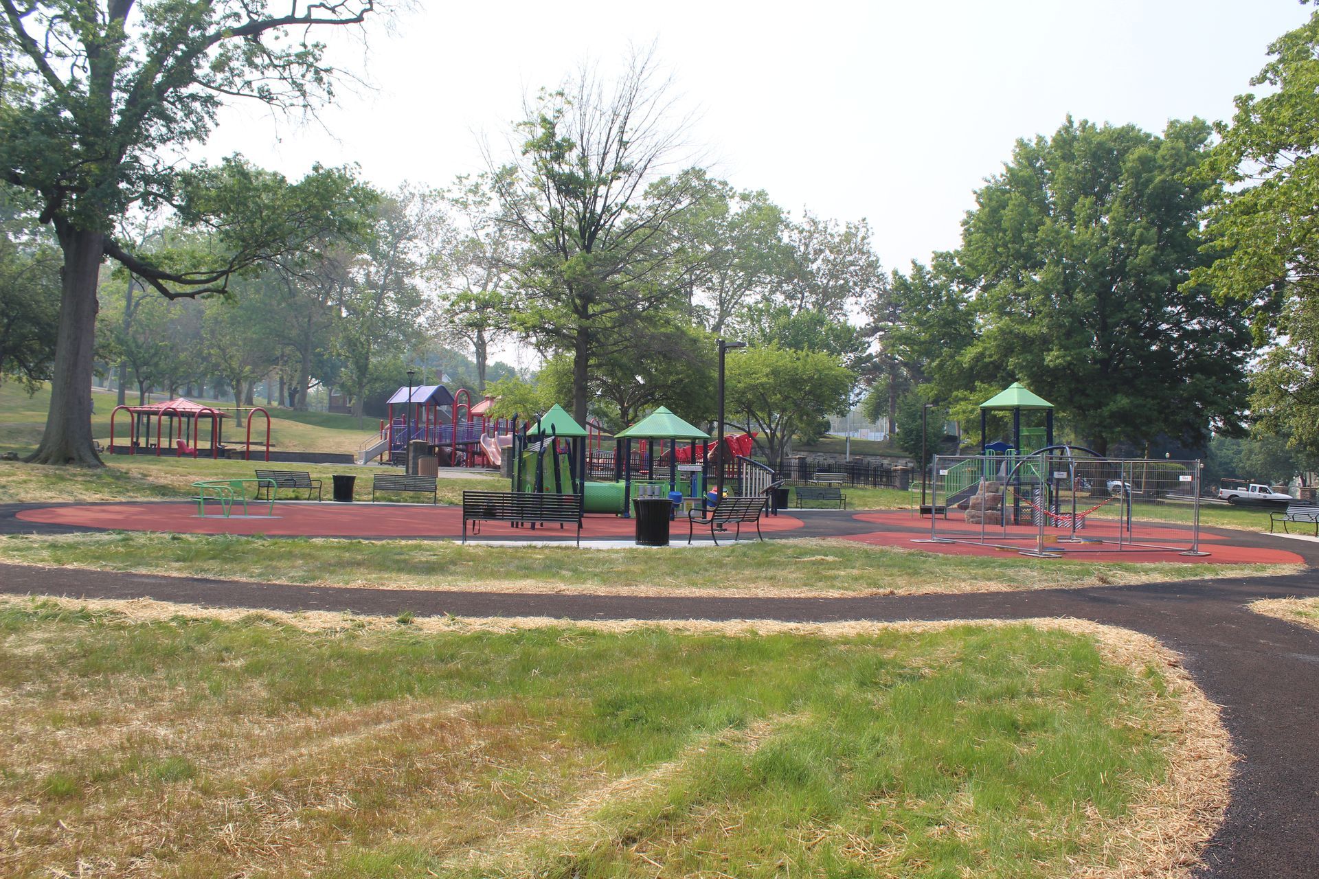 A playground in a park with trees in the background