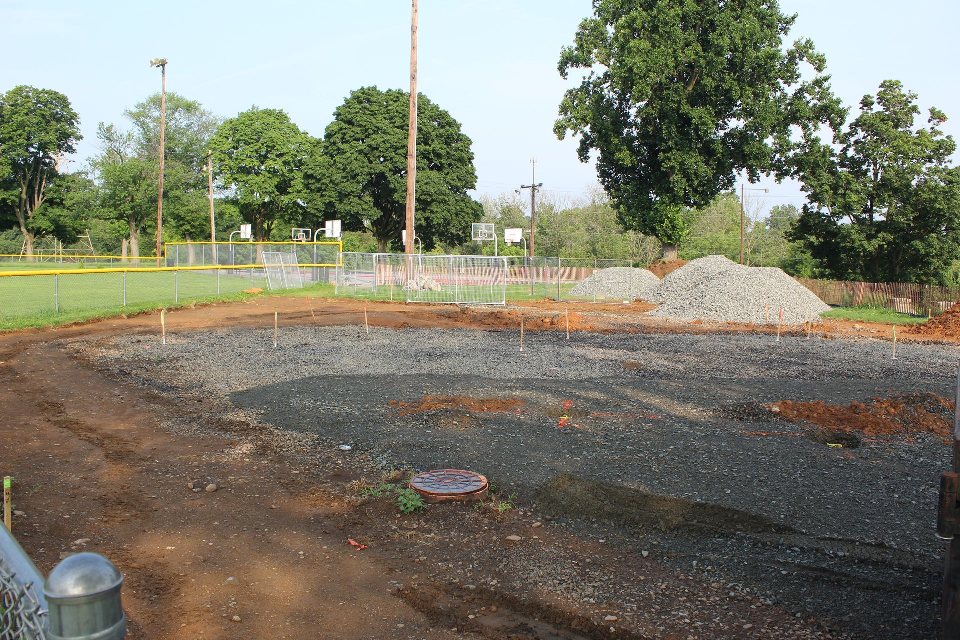 A dirt field with a baseball field in the background