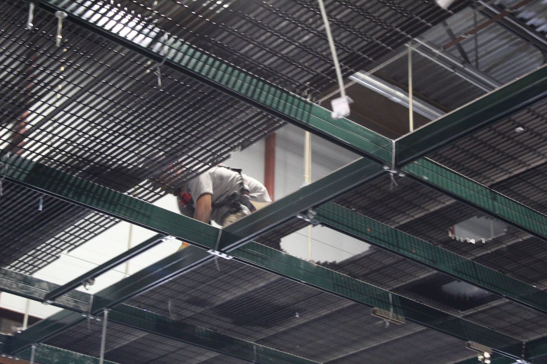 A man is working on the ceiling of a building