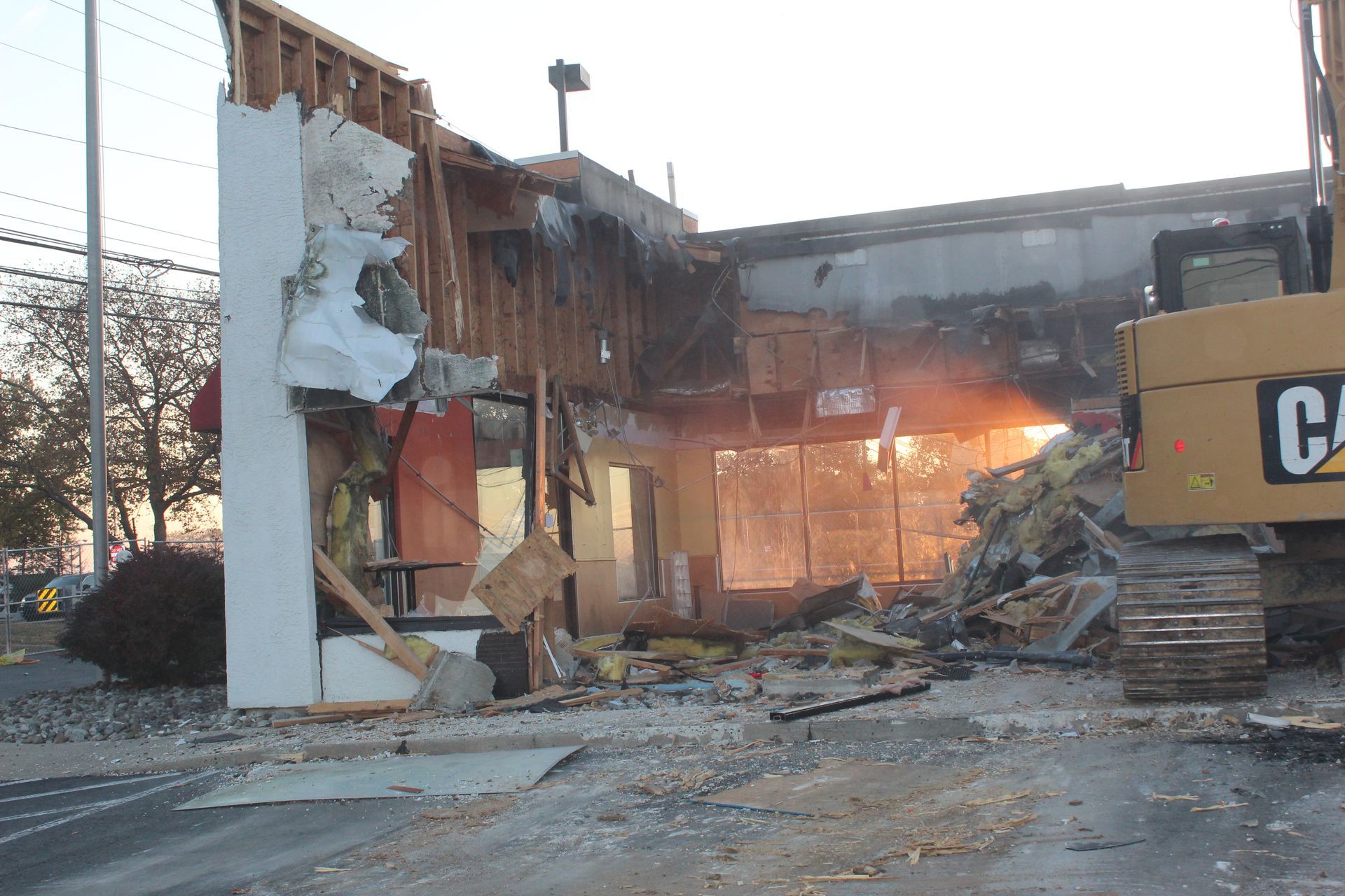 An Empire Services excavator demolishes one side of a restaurant.