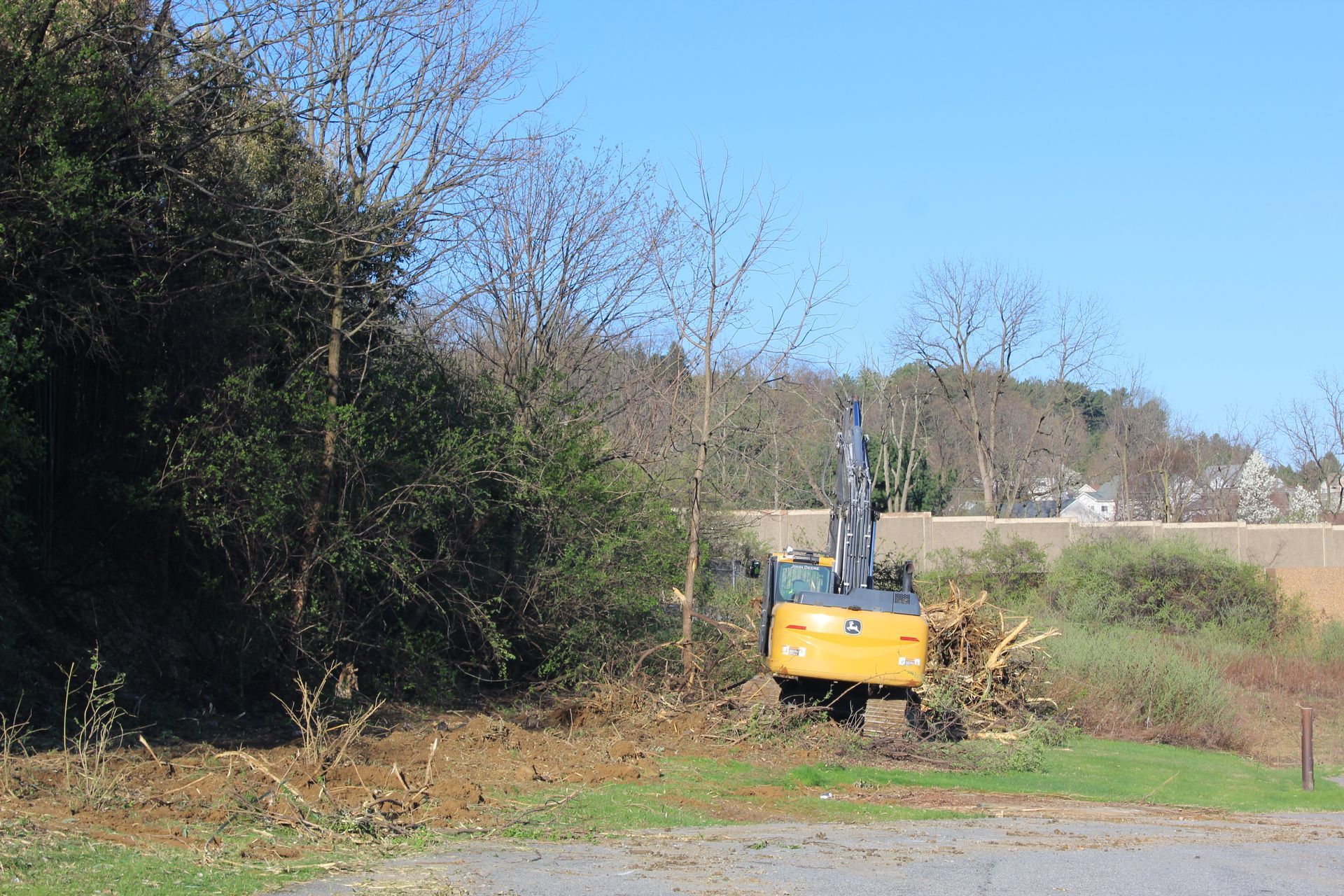 Using an Empire Services' excavator to excavate the area to expand a parking lot.