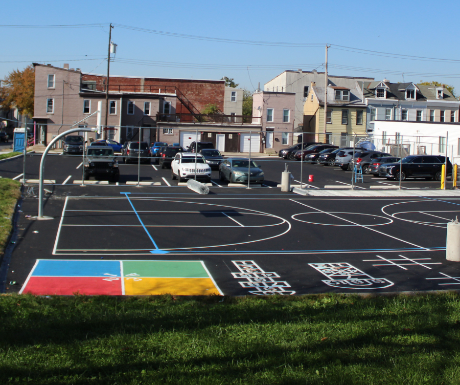 A parking lot with a basketball court in the middle