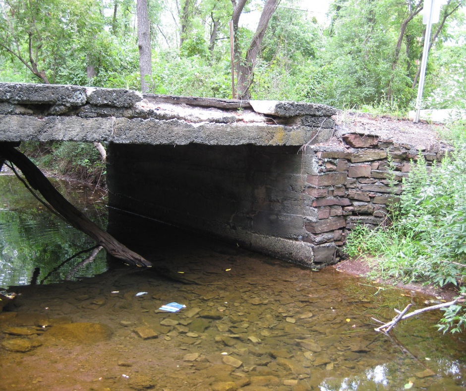 A stone bridge over a stream in the woods
