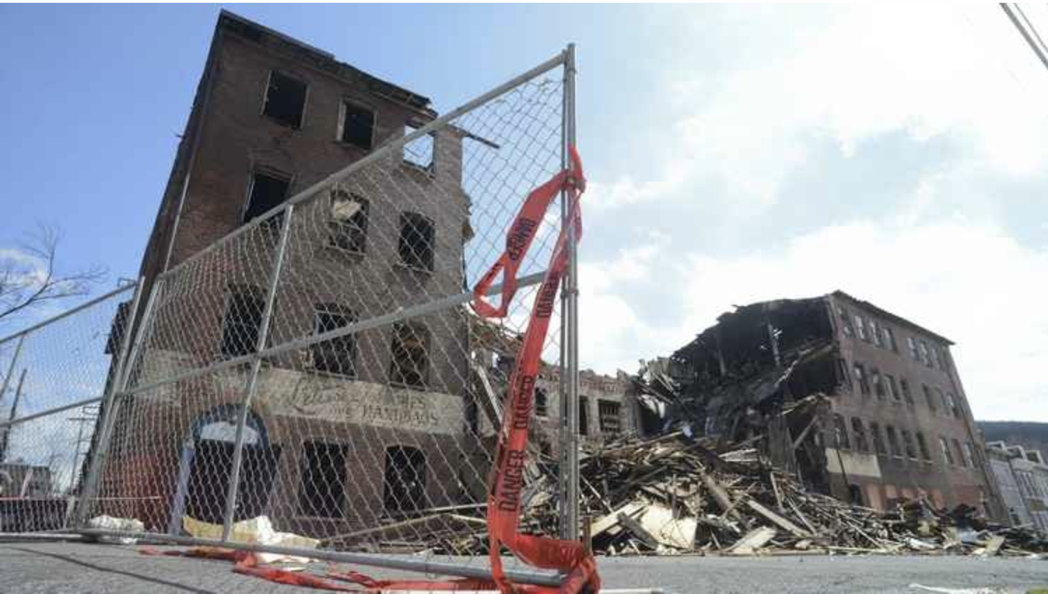 A fence is surrounding a building that is being demolished.