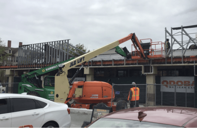 A jlg lift is being used on a building under construction