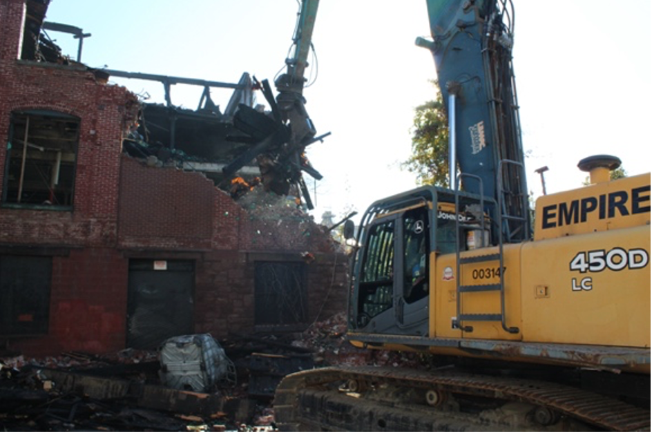 Empire  Services's team uses an excavator to demolished a fire-damaged structure in Reading, PA.