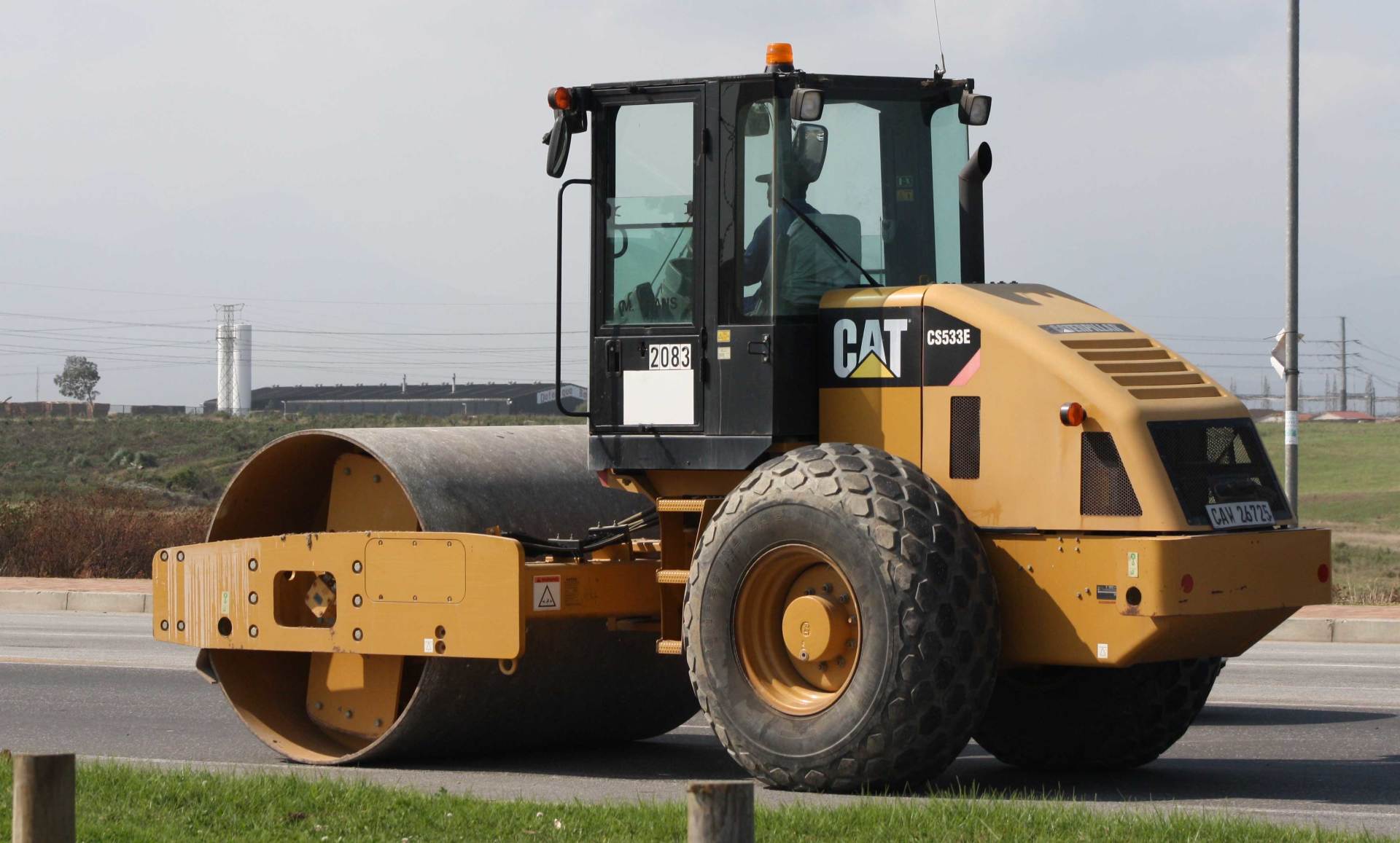 A cat road roller is driving down the road