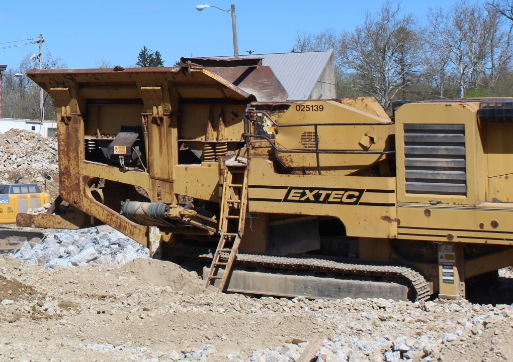 A yellow excavator with the word extec on the side