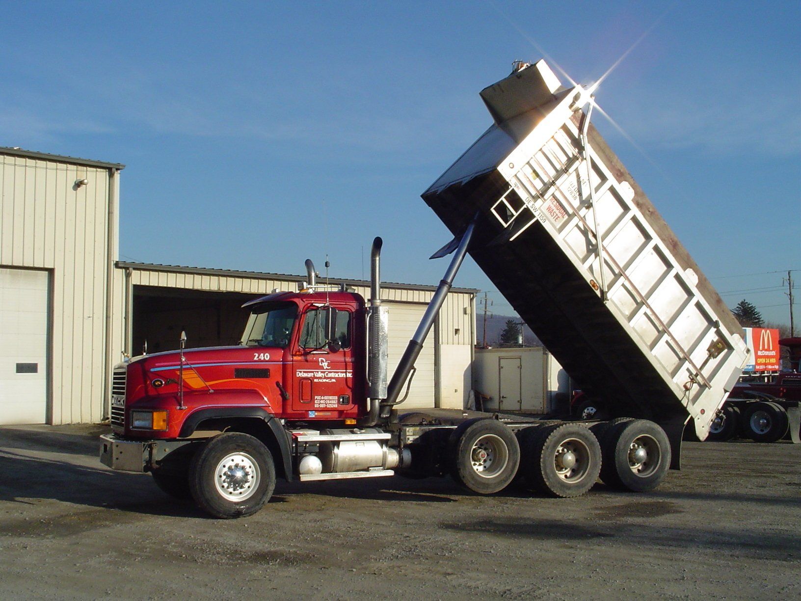A red dump truck is parked in front of a building