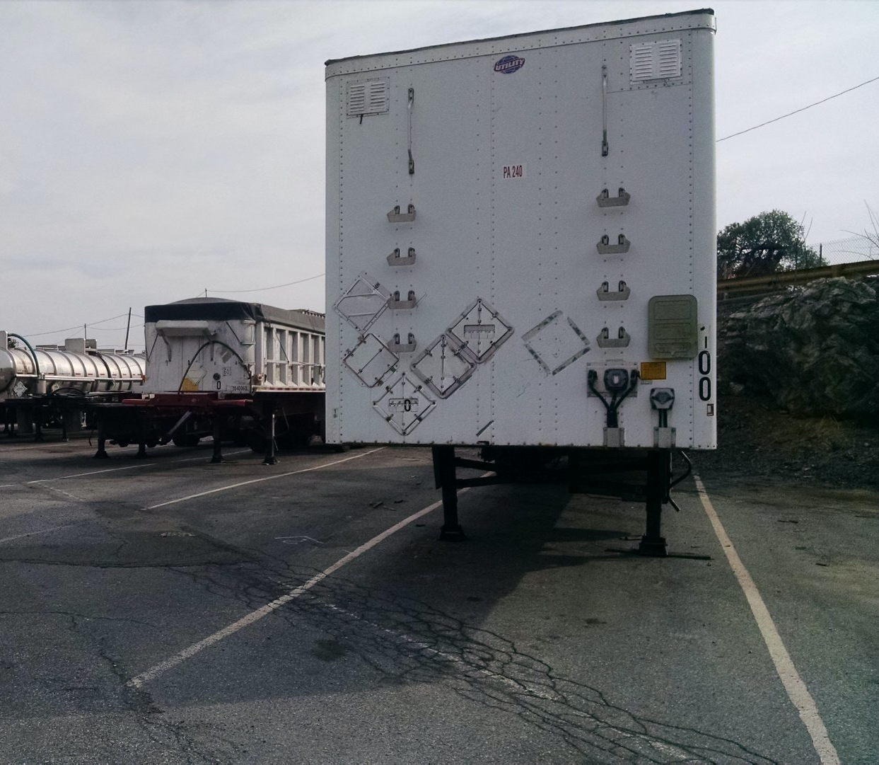 The back of a white trailer has graffiti on it including the letters tp