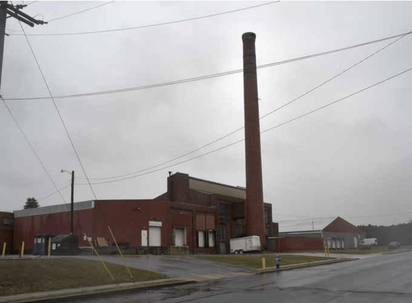 A brick building with a chimney in front of it