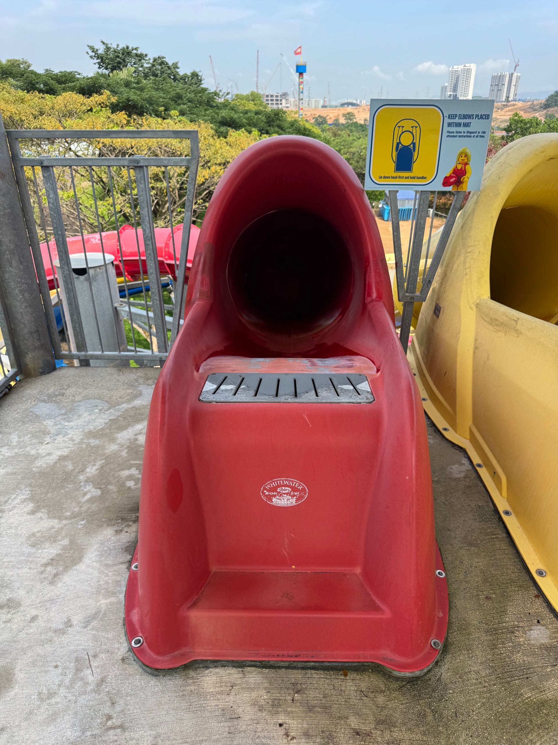 Red waterslide launch chute at Legoland Malaysia showing surface wear before restoration