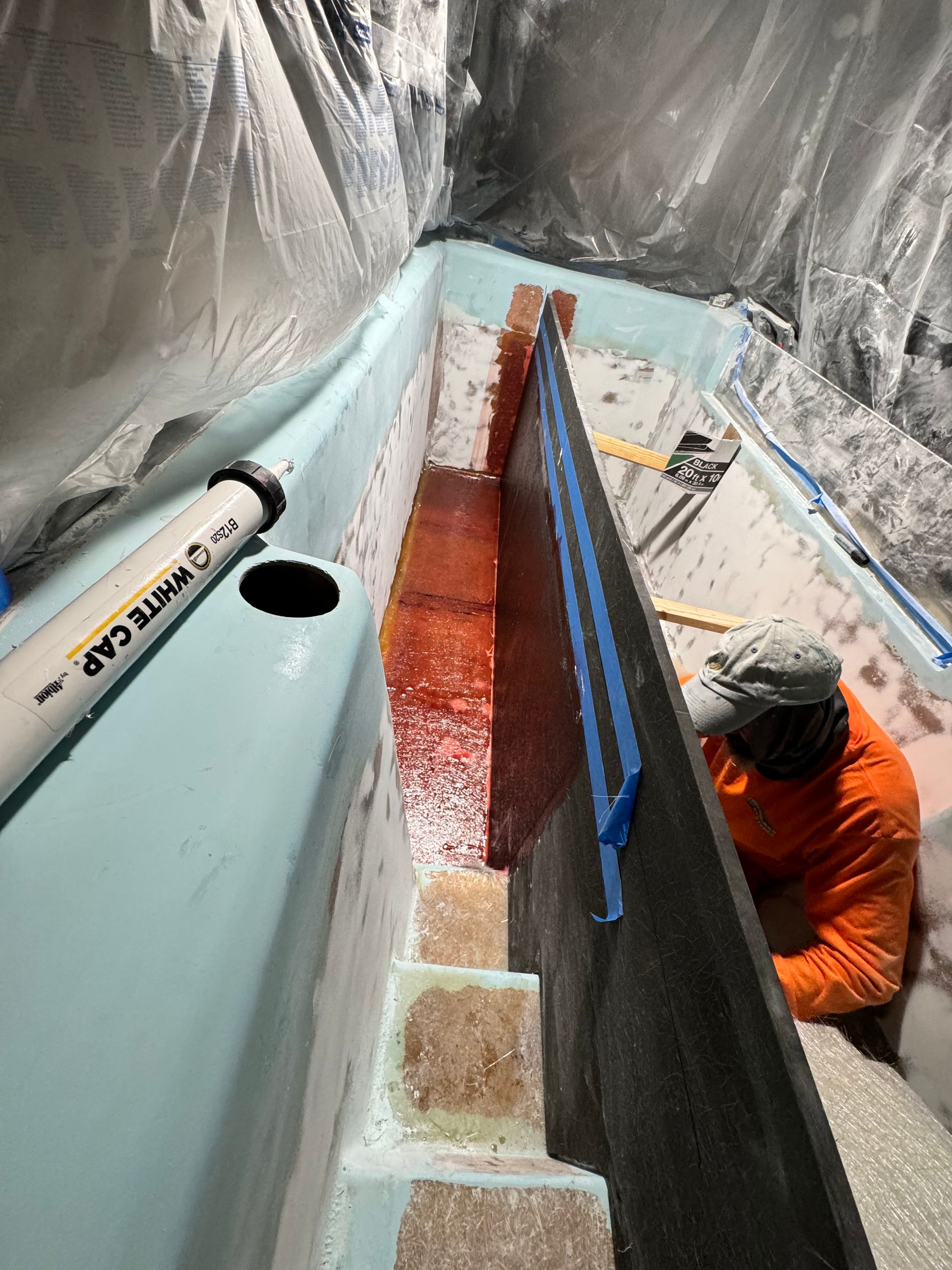 Technician grinding and prepping waterslide surface for fiberglass repair