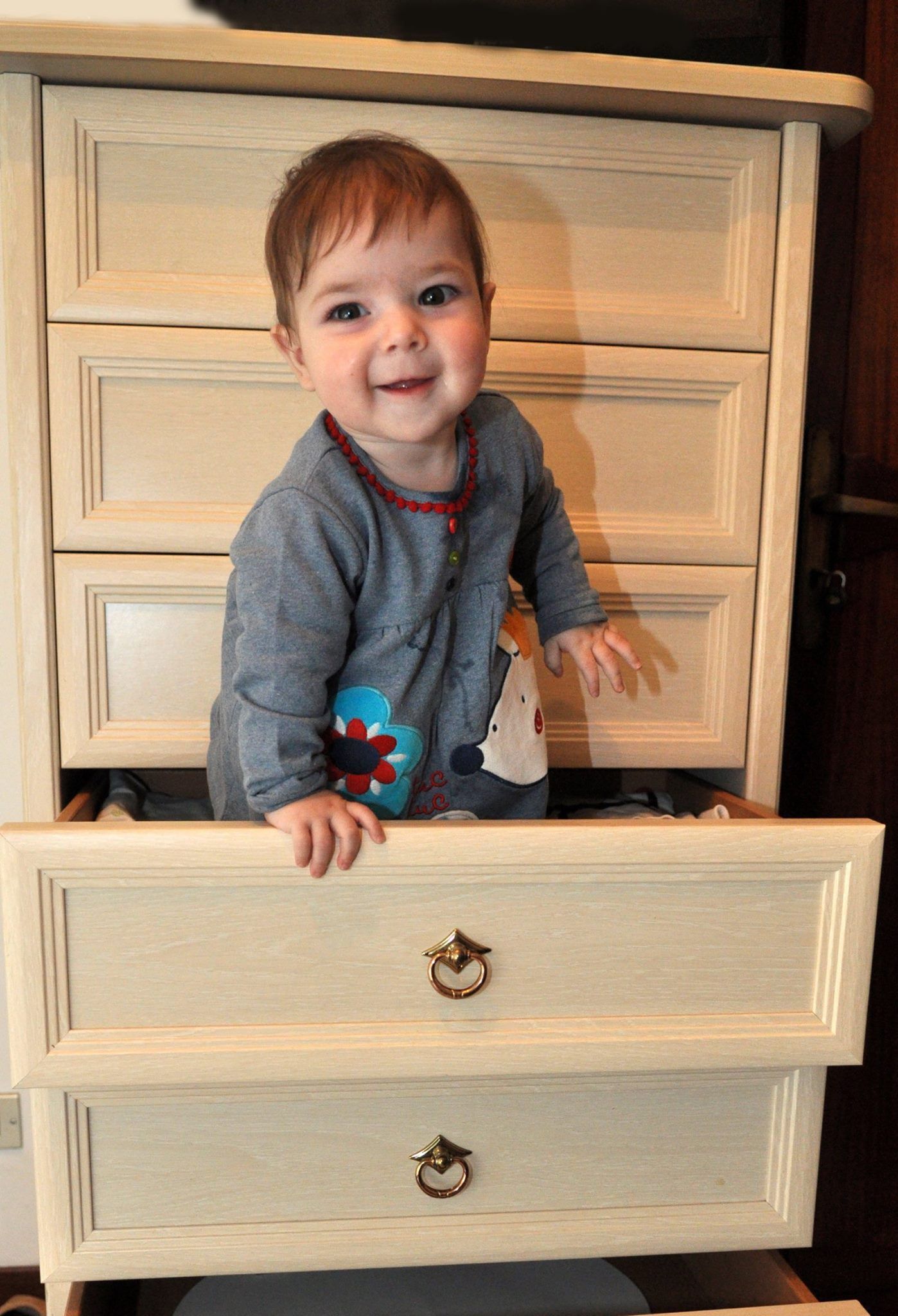 Un ragazzino è in piedi in un cassetto e sorride