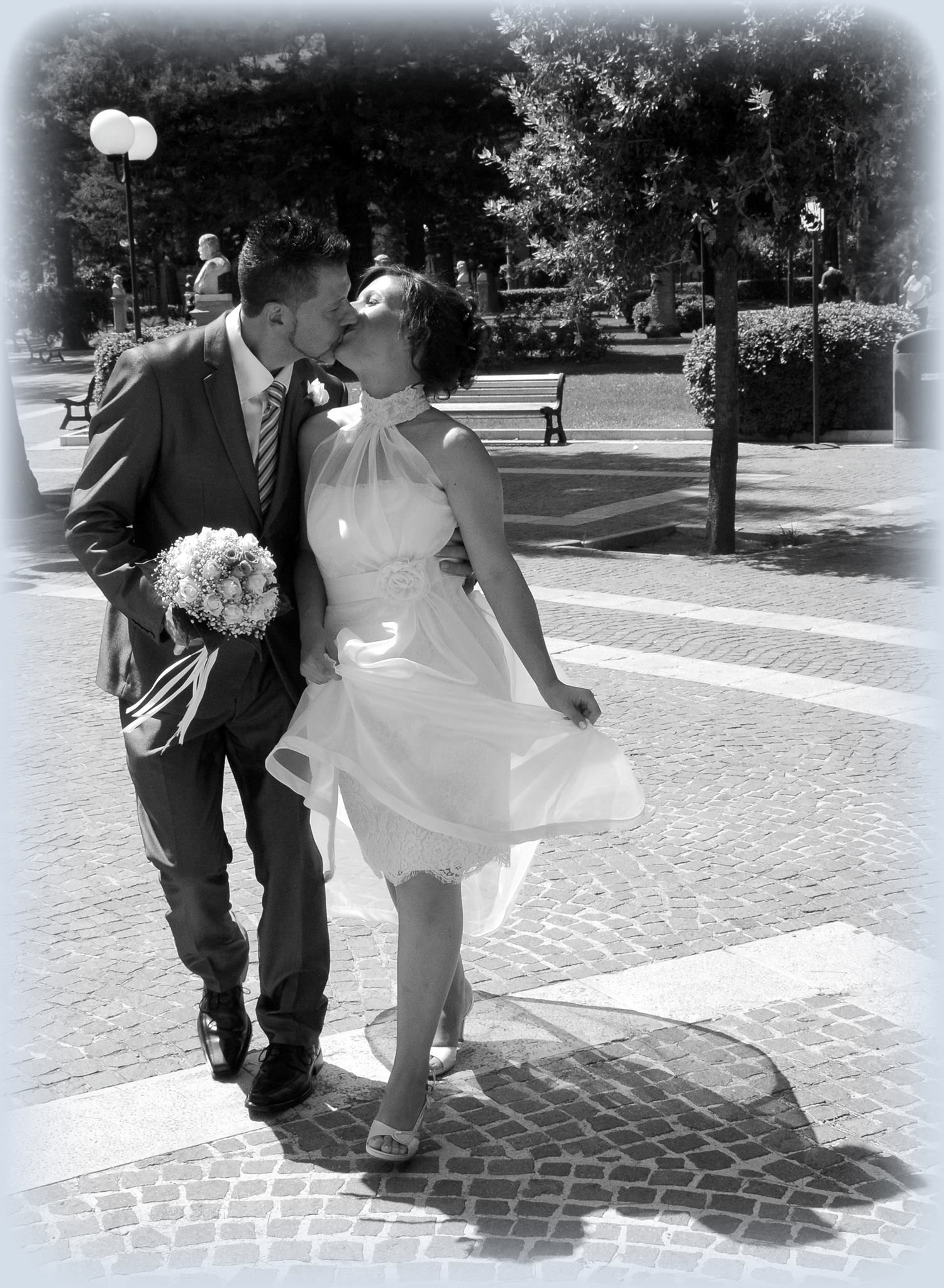 Una sposa e uno sposo che si baciano in una foto in bianco e nero