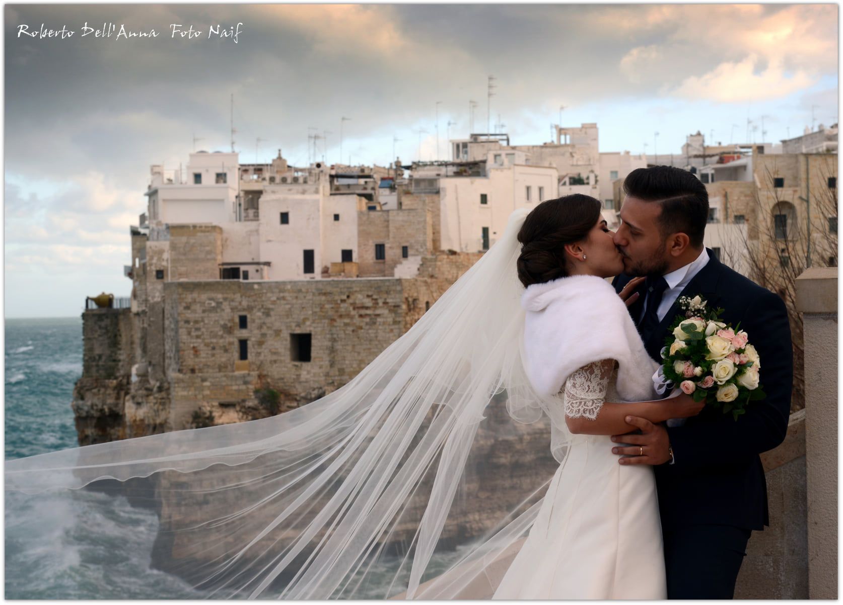 Una sposa e uno sposo che si baciano davanti a un castello