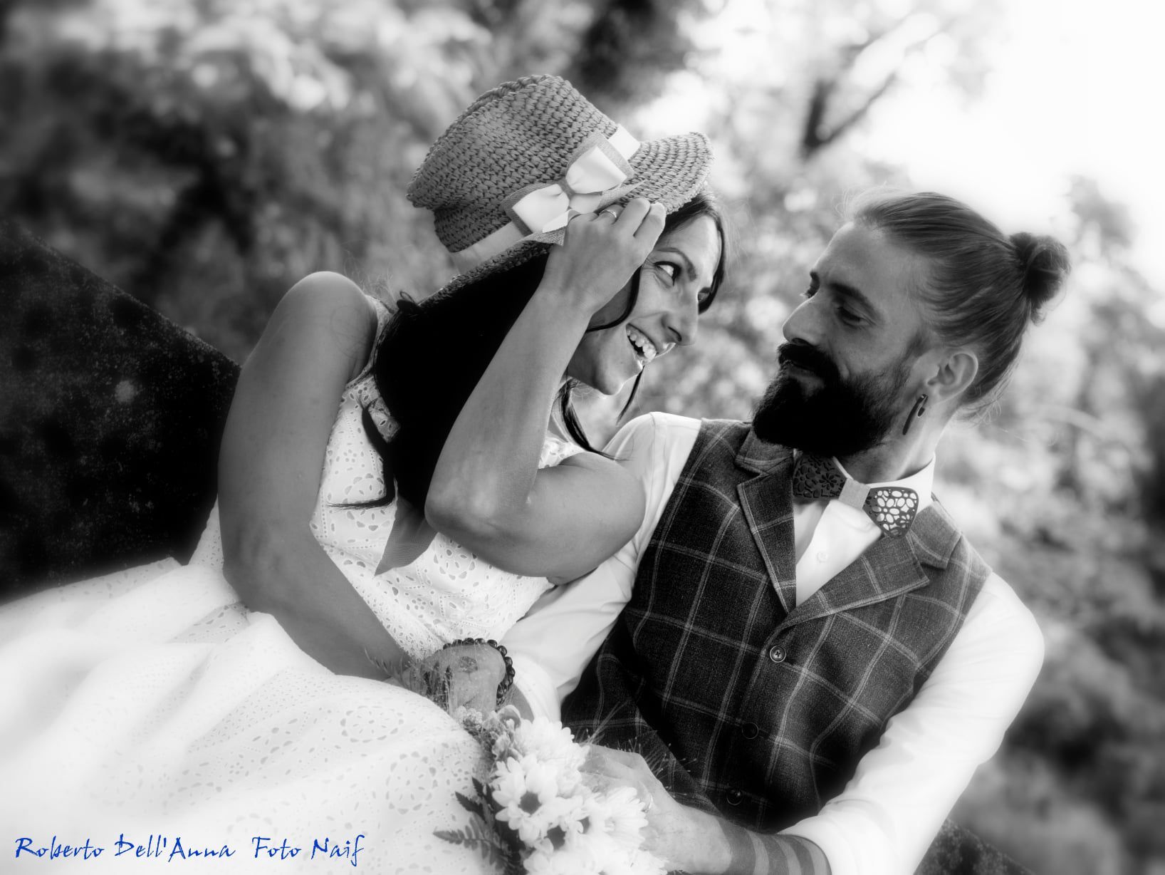 Una sposa e uno sposo posano per una foto in bianco e nero.