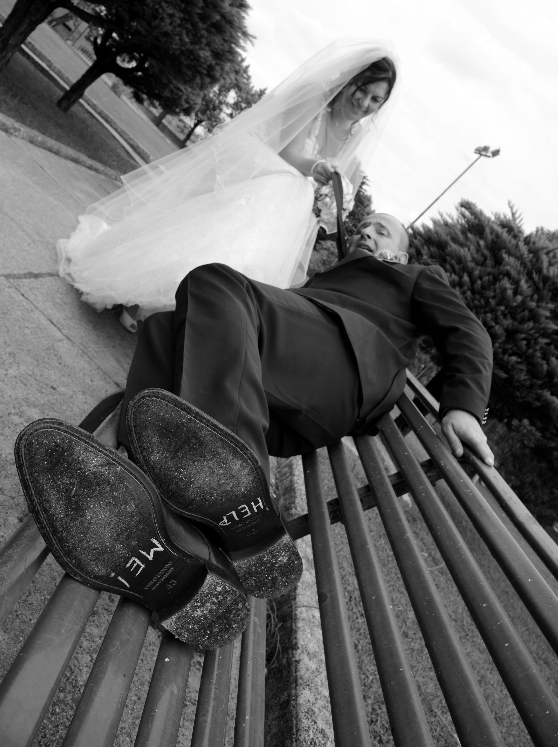 Una foto in bianco e nero di una sposa e uno sposo su una panchina