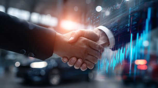 Two businessmen are shaking hands in front of a graph.