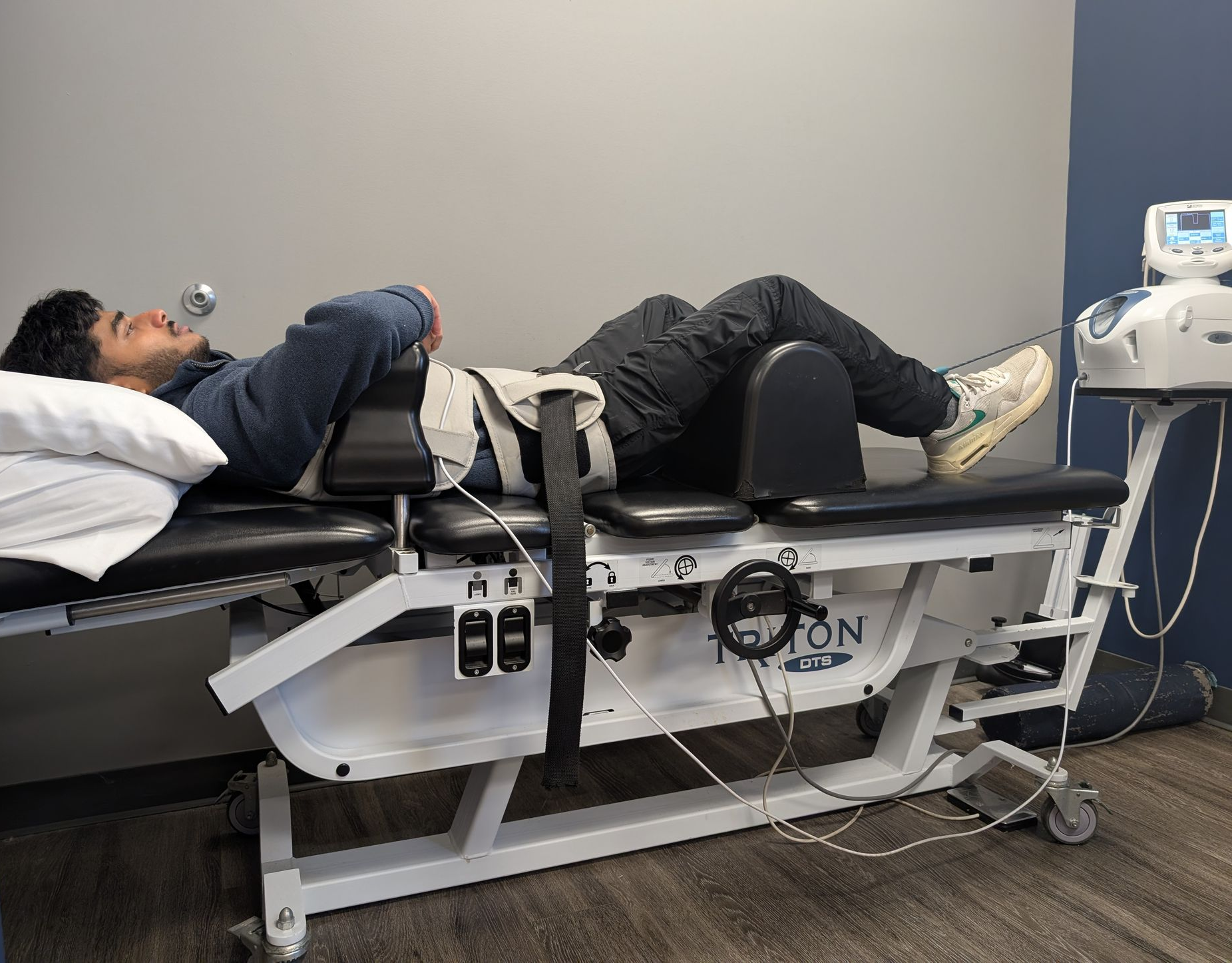 A man is wearing a posture corrector on his back.