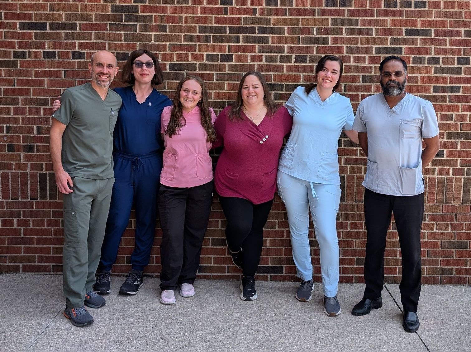 A nurse is stretching a patient 's leg with a purple rubber band.