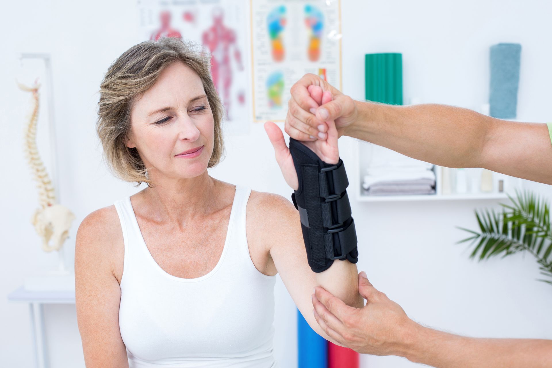 A woman is getting her wrist examined by a doctor.