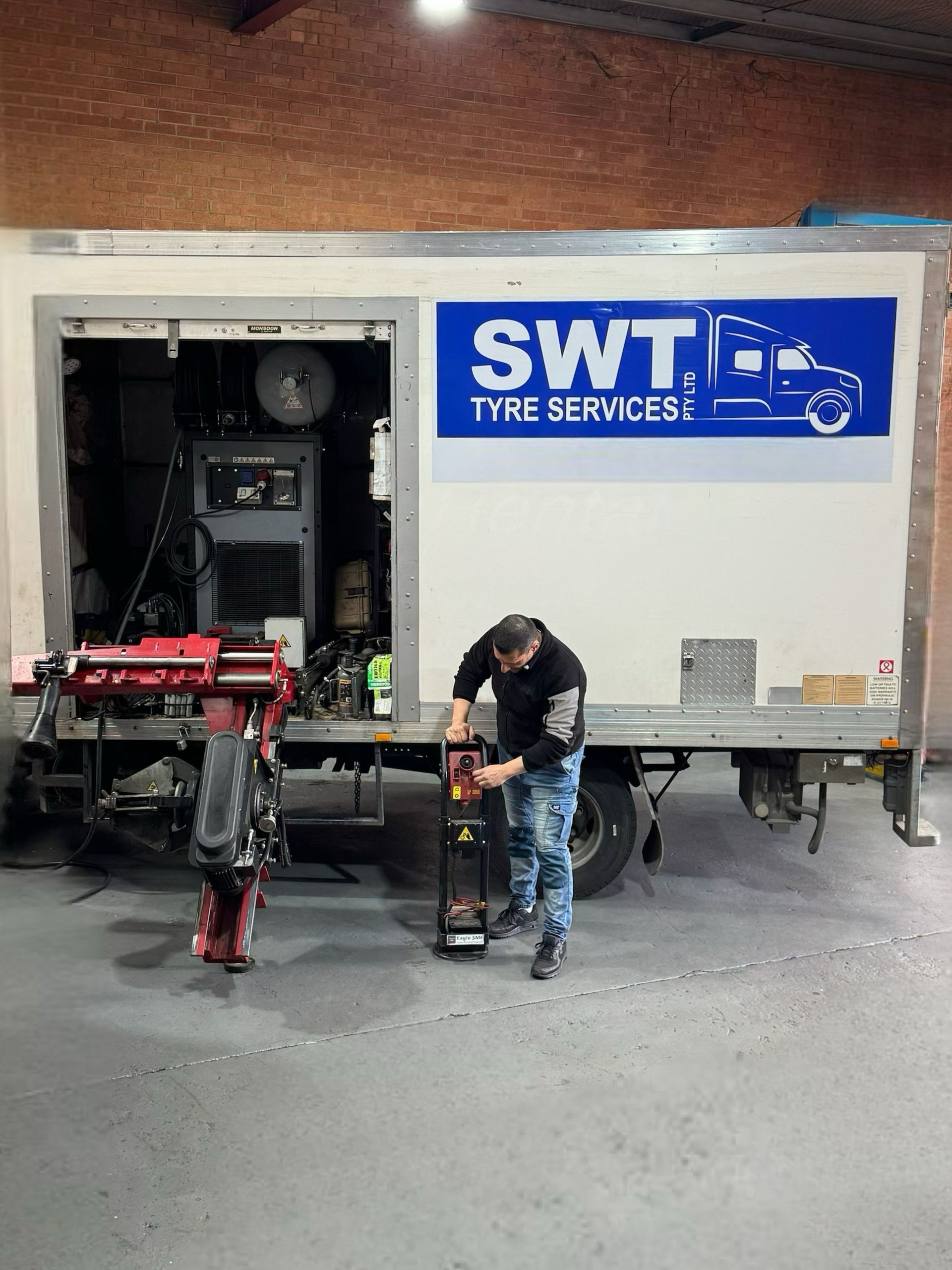 A Mechanic Worker Is Checking The Tire Of A Truck – Fairfield East, NSW - SWT Tyre Services