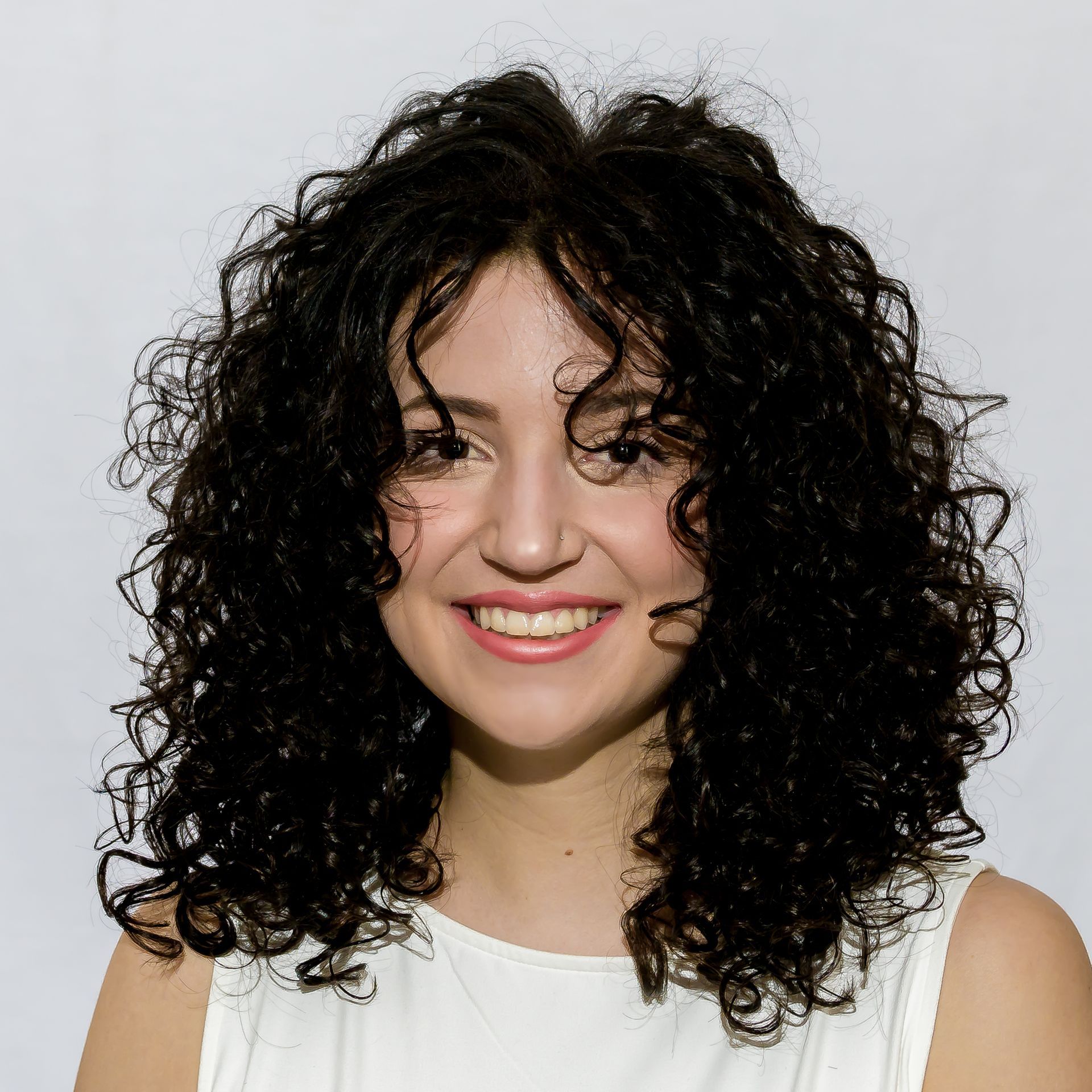A mannequin head wearing a long, layered blonde wig with bangs.
