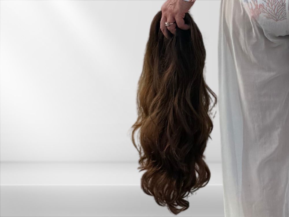 Two mannequin heads: one with a straw hat and auburn hair; the other with a wavy, dark brown wig.