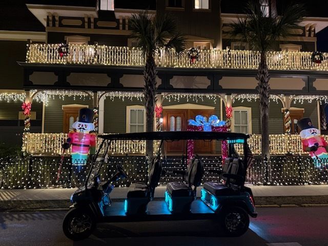 Golf cart with blue underglow parked in front of a house decorated for Christmas.