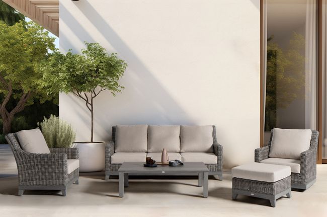 A patio with a couch , chairs , ottoman and coffee table